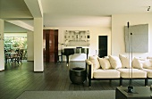 Modernes Wohnzimmer in schwarz-weiß mit dunklem Dielenboden, Heller Couch und Flügelklavier