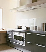 Moderne Einbauküche mit Edelstahlarbeitsplatte und Ceranfeld mit Kochtöpfen