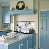 Eine Landhausküche mit blauen Einbauschränken und Dekorationsartikel