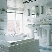 Innenansicht eins weiß gefliesten Badezimmers mit Bachsteinoptik
