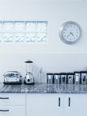 Ausschnitt einer Arbeitsfläche mit Küchengeräten unter Wanddurchbruch mit Glasbausteinen
