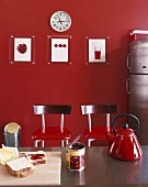 Holzschneidebrett und Toastscheiben mit Konfitüre vor roter Wand