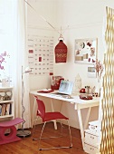 Feminines Kinderzimmer mit Laptop auf Schreibtisch und rosa Dekorationsartikel