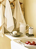 Handtücher am Holzhaken und Äpfel in der Spüle einer Küche