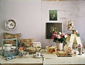 Diverses Geschirr mit Blumenmuster und Blumenvasen auf rustikalen Holztisch
