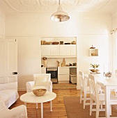 Heller Wohn- und Essbereich einer Altbauwohnung mit Wanddurchbruch und Blick in die Küche