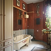Ein Badezimmer mit roten Wänden und Badewanne unter Wandspiegel