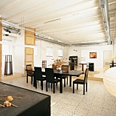 Open-plan interior with central dining table and chairs, tiled floor and living area on platform
