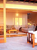 Wohnzimmer mit grauer Couchgarnitur und quadratischem Couchtisch im warmen Abendlicht