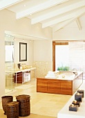 Free-standing, wood-clad bathtub in modern bathroom with beamed ceiling and large glass window