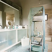Zeitgenössisches Badezimmer mit Steinfliesen und Mosaikfliesen, Waschtisch mit opaken Schiebetüren aus Glas und einem freistehenden Metallregal