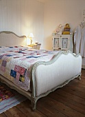 Doppelbett mit geschwungenen und gepolsterten Bettenden und einer Patchwork-Decke