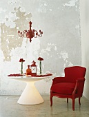 Roter Sessel neben beleuchteten runden Tisch mit Blumendekoration unter roten Kronleuchter