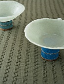 Two bowls on stands decorated with beads