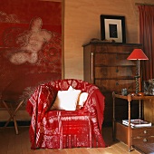 Sessel mit roter Decke vor zeitgenössisches Gemälde