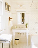Helles Badezimmer mit Tageslicht und antikem Waschbecken unter Wandspiegel