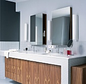 Doppelwaschbecken unter zwei Wandspiegel im Badezimmer mit grauen Glasbausteinen