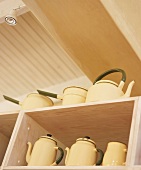 Teapots and coffeepots on shelves