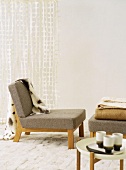 Upholstered easy chair with blanket and footstool