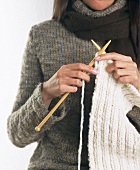 Woman knitting and wearing woollen jumper