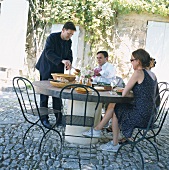 Vier Freunde essen im Freien