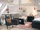 Ein Schlafzimmer mit zwei französischen Metallbetten und antikem Sessel im Dachgeschoss