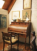 Alter Sekretär mit Holzstuhl in einem rustikalen Raum