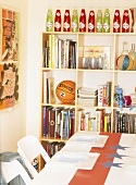 Regal mit Büchern und Spielsachen in einem bunten Kinderzimmer