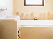 Detail einer lehmverputzten Badewanne mit einfachem Waschbecken