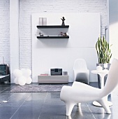 Wohnzimmer mit Designermöbeln vor einer weiss gestrichenen Backsteinwand