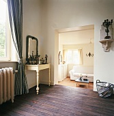 Blick vom rustikalen Hauptraum in ein kleines helles Wohnzimmer mit weisser Couch
