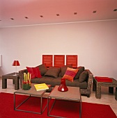 Sofa und Beistelltische aus Rattan hinter zwei filigranen Metallcouchtischen
