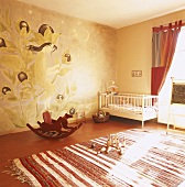 Ein Kinderzimmer in warmen Farben mit Gitterbett, Schaukelpferd und Feenwandbild
