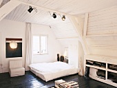 Ein modernes, schlichtes Schlafzimmer im Dachgeschoss mit vertäfelter Decke und sichtbarer Holzbalkenkonstruktion