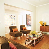 Ein Wohnzimmer mit Vintageholzmöbeln der 60er Jahre und modernen Kunstgemälden