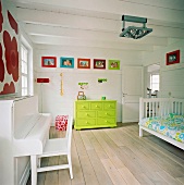 Neongrüne Kommode und bunte Wanddekoration in einem weissen Kinderzimmer