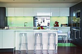 Eine Designerküche mit transparenten Barhockern aus Plexiglas