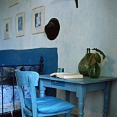 Ein blauer Tisch mit grünen Vasen und ein Stuhl mit Sitzkissen