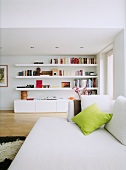 Blick über das Sofa zur modernen Regalkombination mit Wandboards und Lowboard