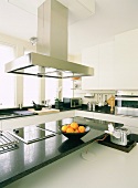 Eine moderne Designereinbauküche mit Granitoberflächen und Edelstahlelementen