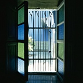 Die Blauen und Grünen Scheiben des geöffneten Fensters ergänzen die Wandgestaltung des orientalischen Innenhofs