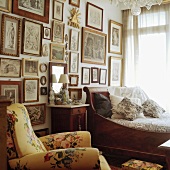 Eine Bilderwand im Schlafzimmer mit Biedermeierbett und floralem Polstersessel