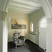 Barocker Sessel im Hausflur mit Holzbalkendecke und Rundbogenelementen