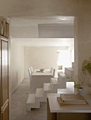 Minimalistische Kalksteinarchitektur im weissen Esszimmer mit Treppenaufgang