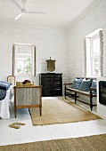 Antike Möbel im weissen Schlafzimmer mit Dielenboden, Steinwänden und Holzbalkendecke