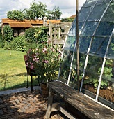 Ländliche Terrasse und Glasanbau mit Blick auf den Garten