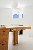 Futuristischer Holztisch mit Schubladen in einem puristischen Raum