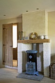 Antiker, ornamentierter Ofen in der rustikalen Kaminnische eines Landhauswohnzimmers