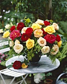 Vase of mixed roses on garden table