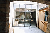Blick aus einem Durchgang in den Innenhof mit Theke und reflektierender Glasfront
